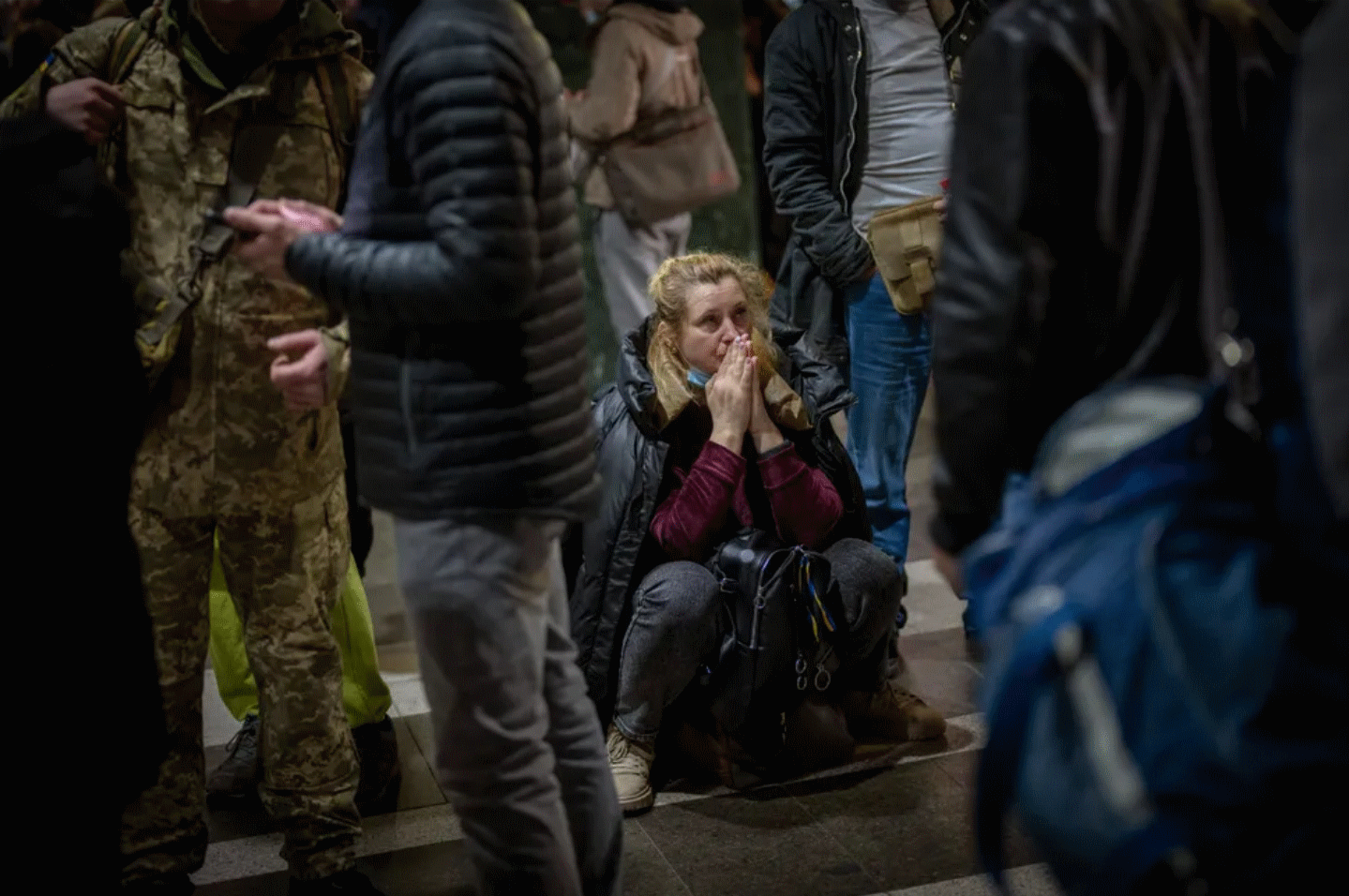 A Ukrainian woman prays in a Kyiv train station. Retrieved from the Huffington Post.