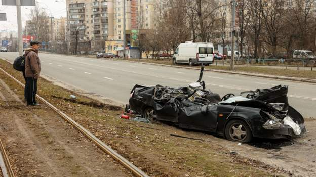 A Ukrainian civilian vehicle in Kyiv, crushed by an armored vehicle (likely Ukrainian). Retrieved from unknown, but likely the BBC.